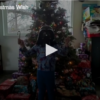 Christmas tree with a boy in a vader mask standing in front of it