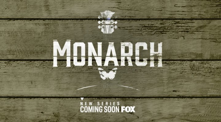 logo for monarch in white paint style block letters with a partial guitar on a wooden background